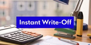 Instant asset write-off concept with calculator, office supplies, and financial documents on a desk