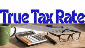 True tax rate concept with calculator, glasses, coffee and financial documents on desk