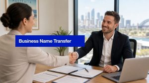 Business professionals shaking hands during an Australian business name transfer meeting with documents and laptop on desk