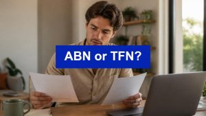 ABN or TFN - freelancer comparing tax forms at a home desk